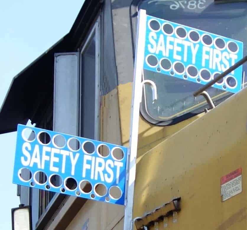 Perforated blue safety flags deployed on a staff at a locomotive cab